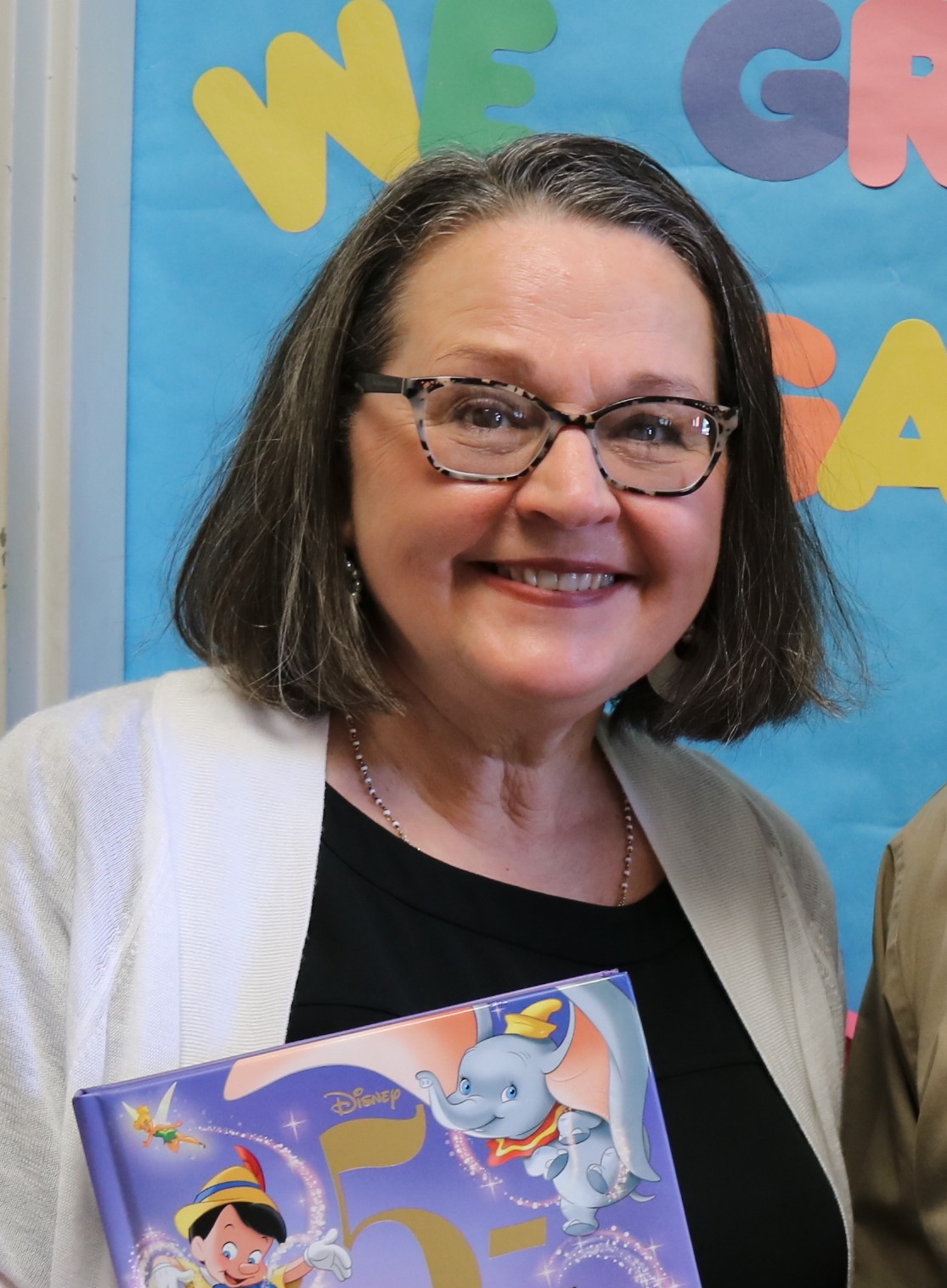 Patty holding a Disney-themed children's book.